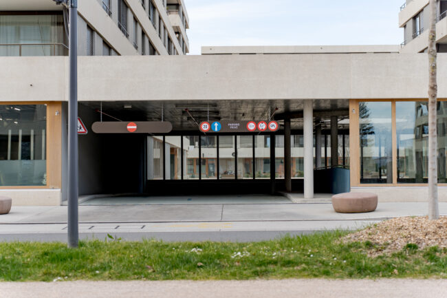Entrée d'un parking privé souterrain avec signalétique réglementaire (sens interdit, hauteur limitée à 2,2 m, interdiction GPL, tonnage 3,5 t).